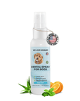 White spray bottle labeled We Love Doodles Dental Spray for Dogs with a blue label and doodle graphic. A Made in the USA tag hangs on the neck. Aloe leaves, orange slices, and mint sit at the base.