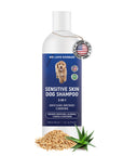 White bottle with a blue label reading Sensitive Skin Dog Shampoo 3 in 1. A Made in USA tag hangs at the neck. Oat flakes and aloe leaves sit at the base on a white background.