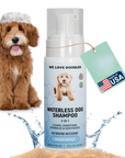 Foam pump bottle labeled Waterless Dog Shampoo 4-in-1 Ocean Breeze beside a fluffy doodle with suds on its head, water splashes and sand at the base, plus a Made in USA hang tag.