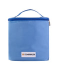 Light blue soft sided grooming bag shown upright and closed. A top carry handle and full zip lid are visible with a small We Love Doodles logo patch on the front
