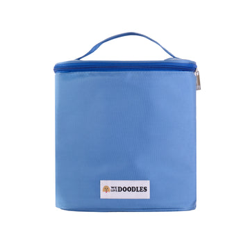 Light blue soft sided grooming bag shown upright and closed. A top carry handle and full zip lid are visible with a small We Love Doodles logo patch on the front