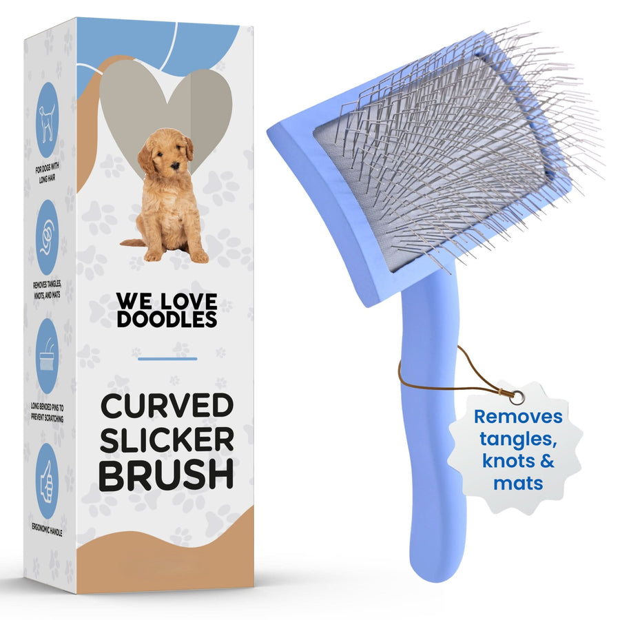 Blue curved dog slicker brush with angled pins positioned next to branded packaging. A hanging tag states removes tangles, knots and mats.