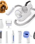 White pet grooming vacuum with a clear 2L canister and coiled hose. Shown with white and blue tools including clipper, slicker brush, nail grinder, paw trimmer, hair remover roller, and comb guards on a plain background.