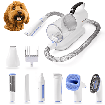 White pet grooming vacuum with a clear 2L canister and coiled hose. Shown with white and blue tools including clipper, slicker brush, nail grinder, paw trimmer, hair remover roller, and comb guards on a plain background.