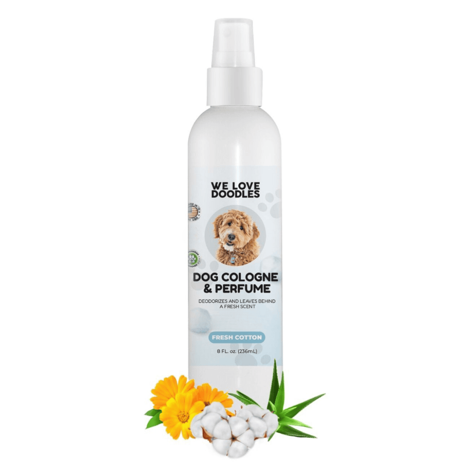 White We Love Doodles dog cologne in the Fresh Cotton scent on a white background. Cotton bolls, calendula flowers, and aloe leaves sit in front of the bottle.