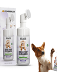 Bottle and box of We Love Doodles Dog Paw Cleaner in lavender with an attached round silicone brush. A dog raises a paw while a hand holds the foaming bottle.