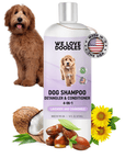 White bottle with a purple label reading dog shampoo detangler and conditioner 4 in 1. A fluffy brown dog sits beside it with a Made in USA tag near the cap. Coconut half sunflower heads and jojoba seeds are at the base.