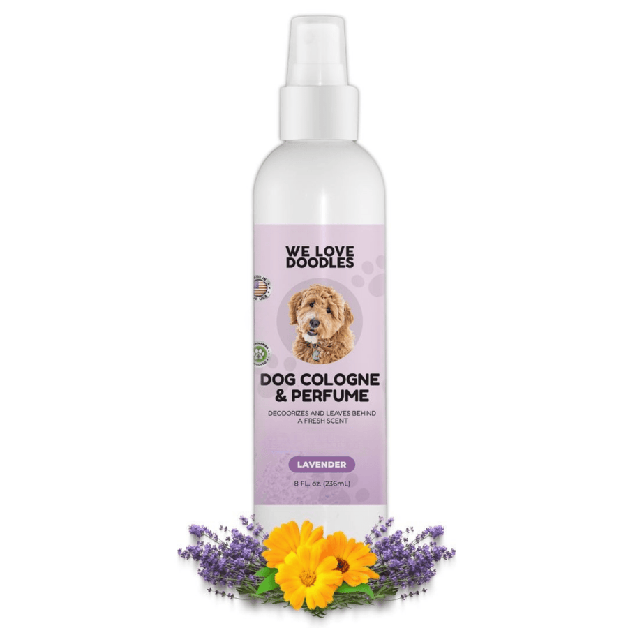 White We Love Doodles dog cologne and perfume in the lavender scent. The bottle stands on a white background with lavender sprigs and yellow calendula flowers at the base.
