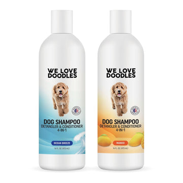 Two white 16 oz bottles on a white background. Left label shows Ocean Breeze with blue wave art. Right label shows Mango with an orange gradient and mango fruit. Both read Dog Shampoo Detangler and Conditioner 4 in 1.