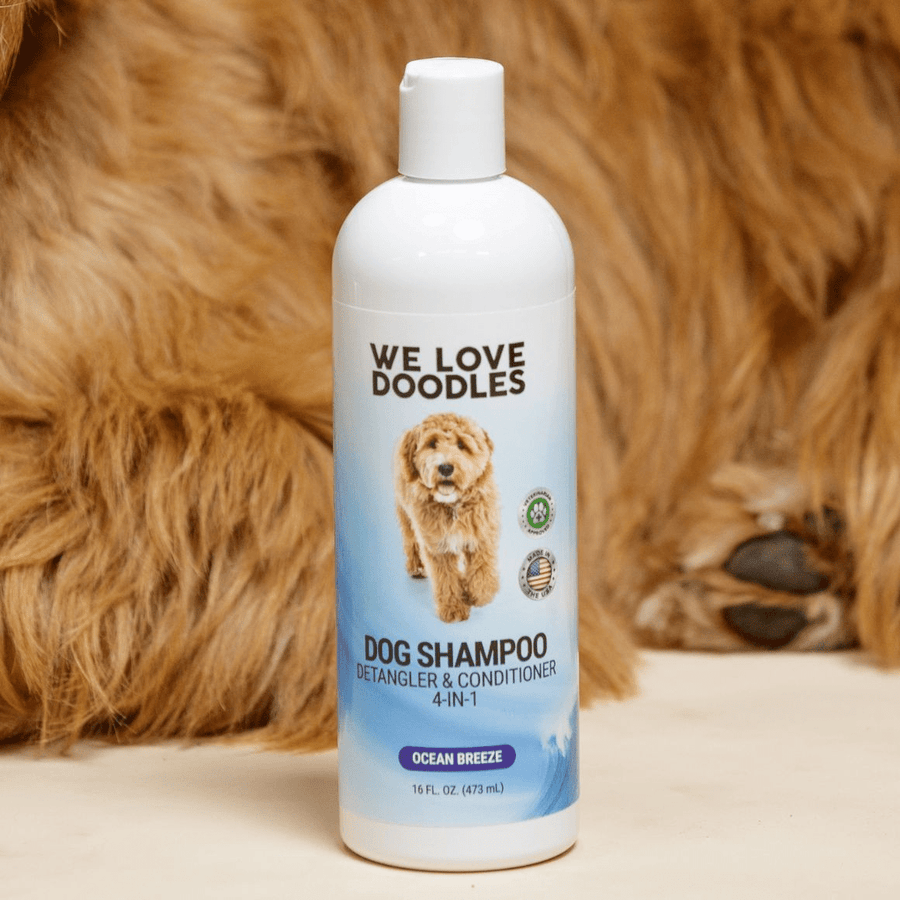 Single 16 oz Ocean Breeze dog shampoo bottle on a cream surface with soft brown fur behind it. Label reads Detangler and Conditioner 4 in 1.