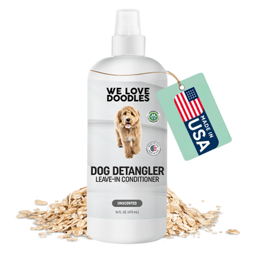 White spray bottle labeled We Love Doodles Dog Detangler Leave In Conditioner unscented 16 fl oz with a doodle photo, a Made in USA hang tag, and oats at the base.
