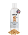 White We Love Doodles Puppy Shampoo bottle with a small puppy graphic. A Made in USA medallion hangs near the cap. Loose oatmeal flakes sit at the base on a clean white background.