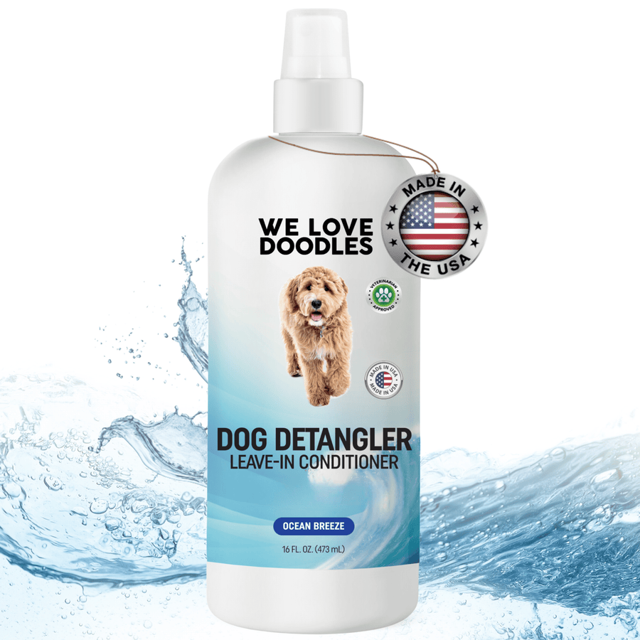 White 16 oz spray bottle labeled Dog Detangler Leave In Conditioner with blue wave graphics and a Made in the USA badge shown over a water splash background.